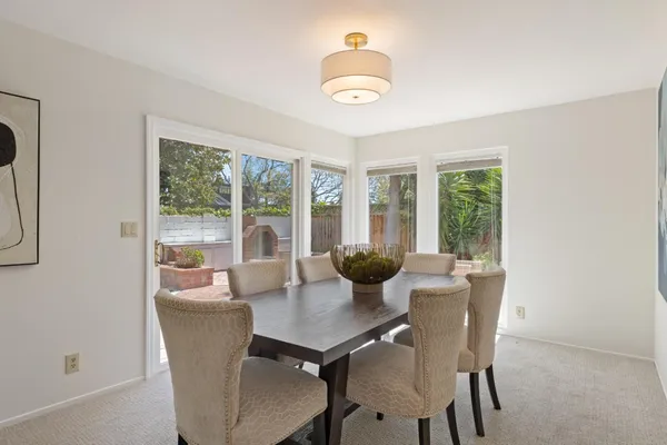 a dining room with furniture a chandelier and wooden floor