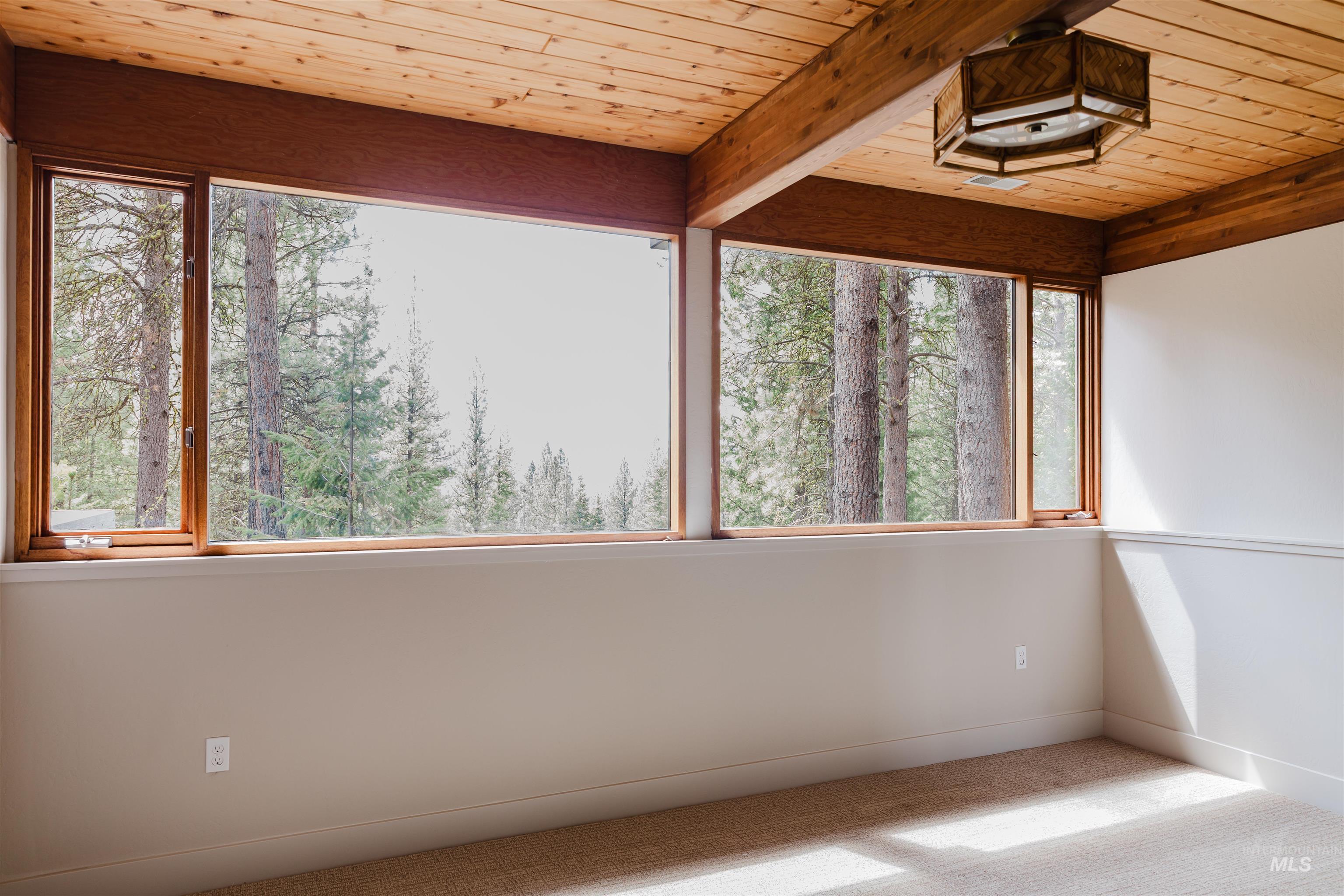 136 Silver Fox Trail McCall, ID 83638 - Photo 13 of 31 Floor-to-ceiling windows with wood frames offer expansive natural scenery