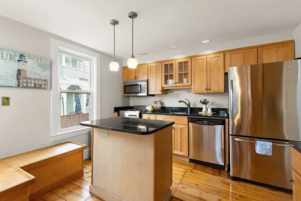 a kitchen with granite countertop a sink appliances cabinets and furniture