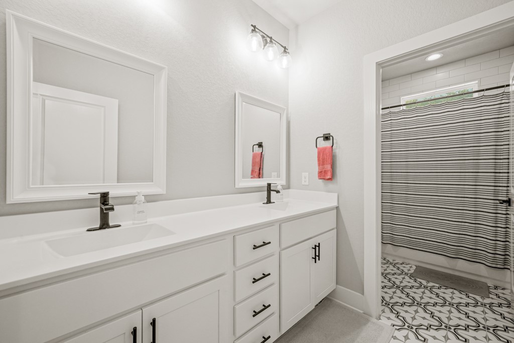 Undisclosed Address Spring Branch, TX 78070 - Photo 23 of 40 a bathroom with a double vanity sink and a mirror