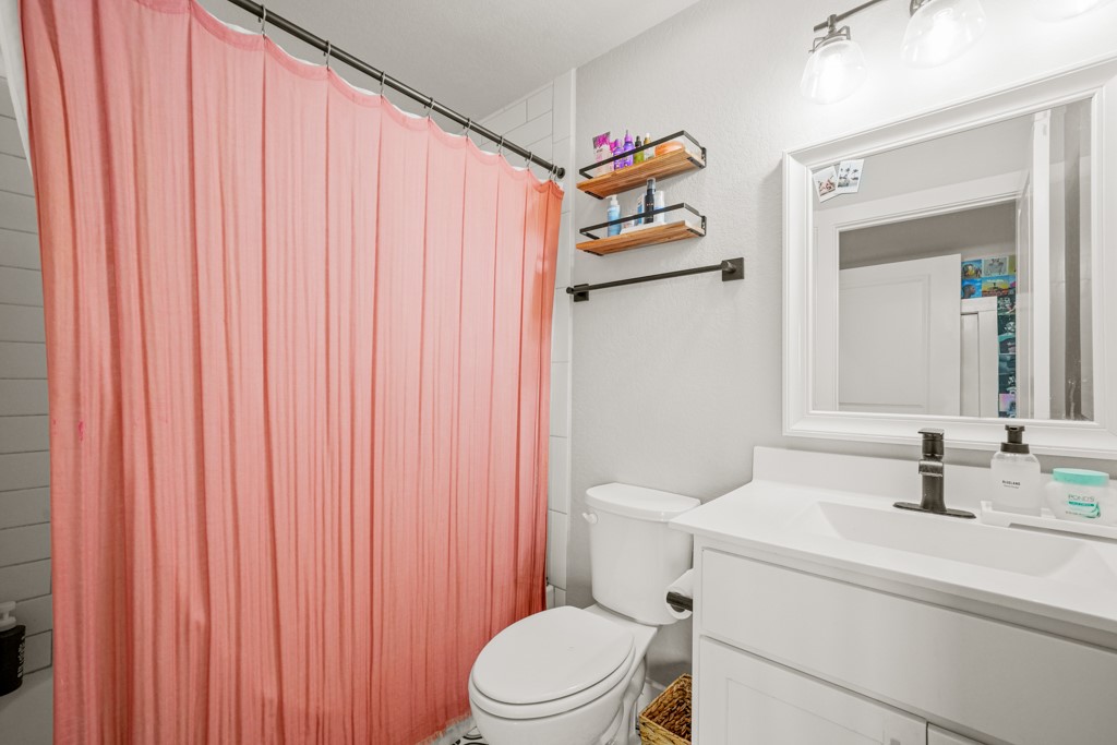 Undisclosed Address Spring Branch, TX 78070 - Photo 25 of 40 a bathroom with a sink a toilet and shower curtain