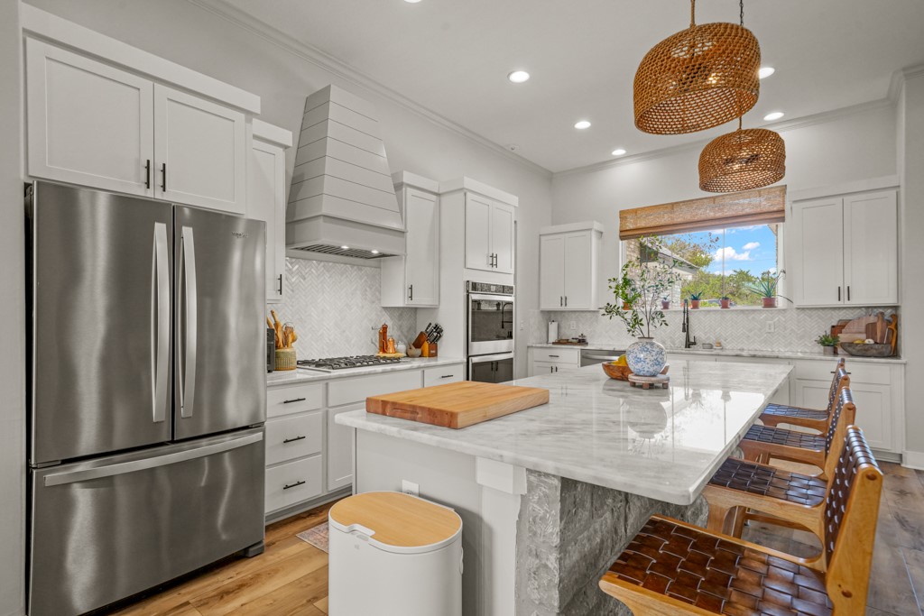 Undisclosed Address Spring Branch, TX 78070 - Photo 9 of 40 a kitchen with refrigerator a stove a sink and a dining table with wooden floor