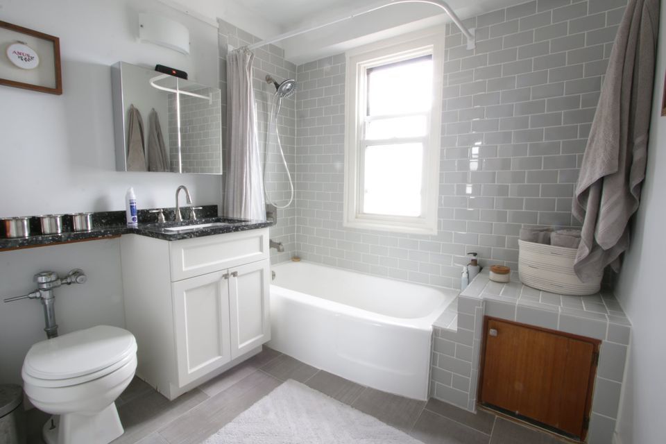 2909 North Sheridan Road, Unit 1502 Chicago, IL 60657 - Photo 12 of 19 a bathroom with a granite countertop toilet sink and mirror