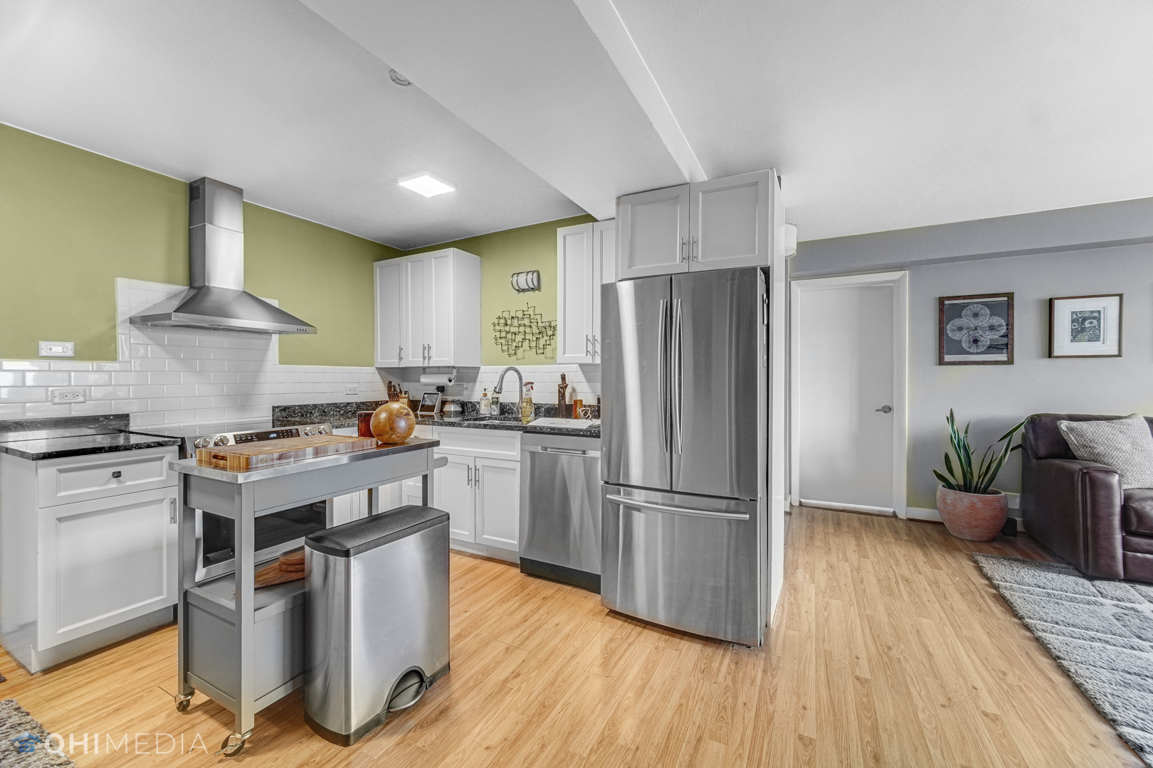 2909 North Sheridan Road, Unit 1502 Chicago, IL 60657 - Photo 5 of 19 a kitchen with a refrigerator a stove top oven a wooden floor and cabinets