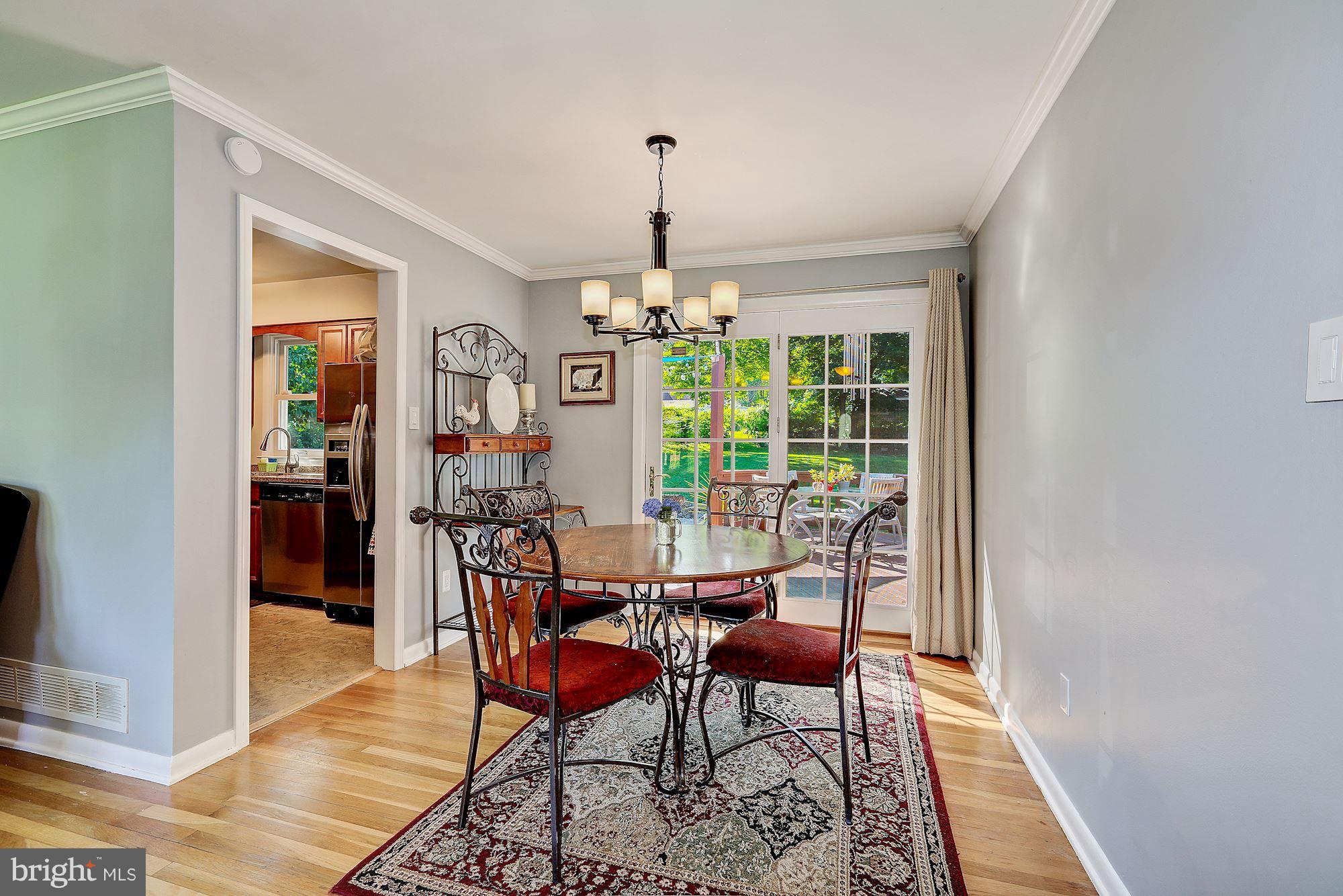 11417 Newport Mill Road Silver Spring, MD 20902 - Photo 3 of 21 a dining room with furniture a chandelier and wooden floor