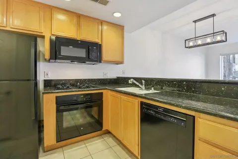 a kitchen with stainless steel appliances granite countertop a sink stove and microwave