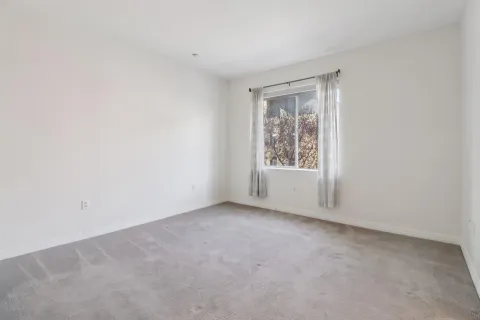 an empty room with closet and mirror