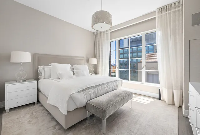 a spacious bedroom with a bed and a large window