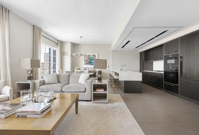 a living room with furniture wooden floor and kitchen view