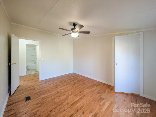 a view of empty room with wooden floor