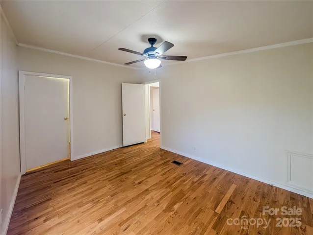 a view of empty room with wooden floor
