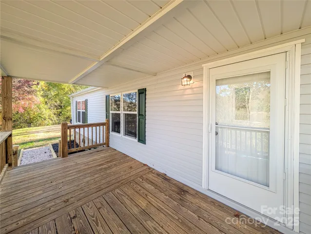 a view of a porch with wooden floor and floor to ceiling window