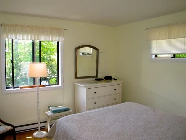 a bedroom with a bed window and mirror