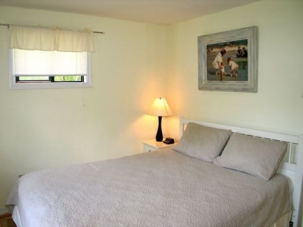 175 Meetinghouse Way Edgartown, MA 02539 - Photo 18 of 21 a bedroom with a bed and a lamp