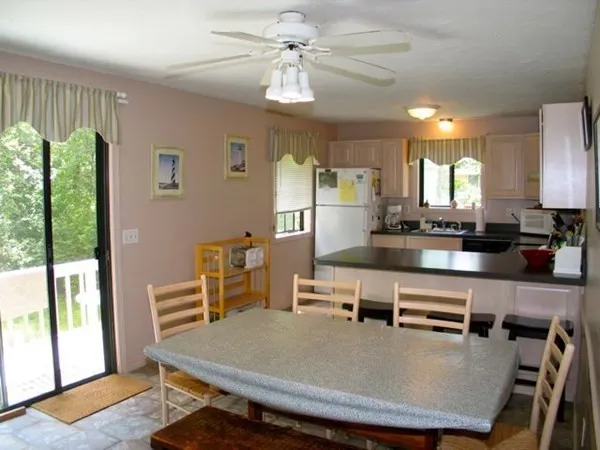 a kitchen with a table chairs refrigerator and microwave