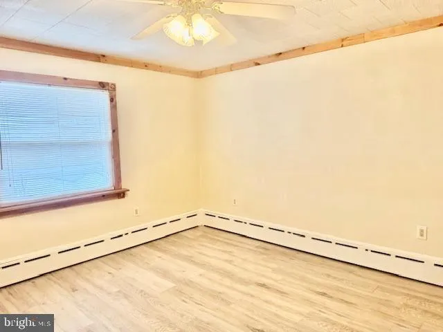 a view of a small space with wooden floor and a window