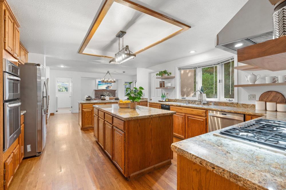 10930 Miramonte Road Cupertino, CA 95014 - Photo 13 of 50 a large kitchen with stainless steel appliances granite countertop a lot of counter space and wooden floors