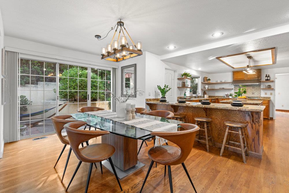 10930 Miramonte Road Cupertino, CA 95014 - Photo 21 of 50 a dining room with stainless steel appliances kitchen island granite countertop a table chairs and a chandelier