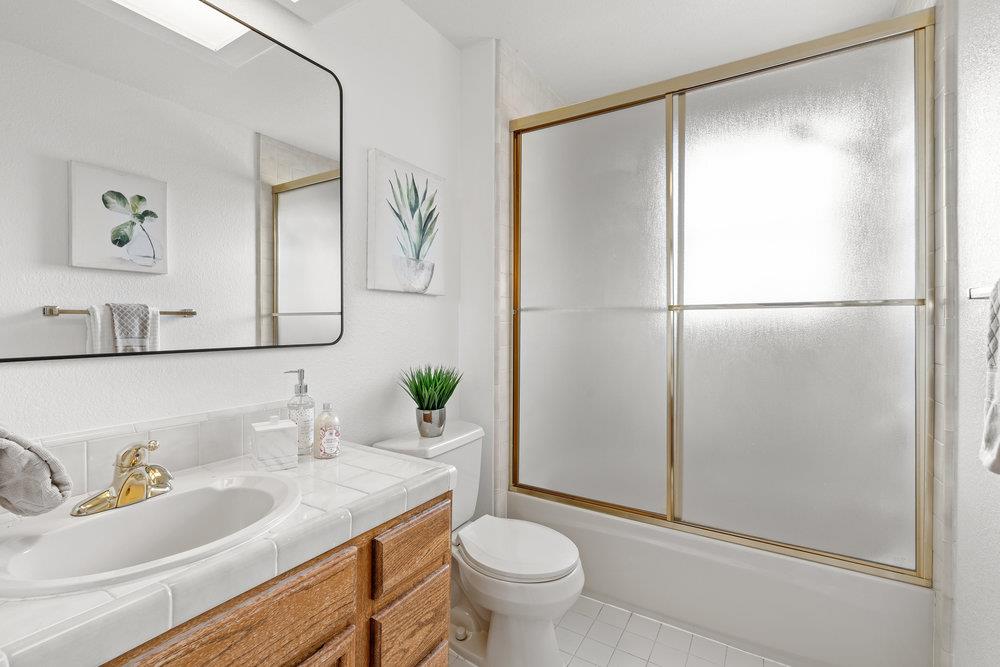 10930 Miramonte Road Cupertino, CA 95014 - Photo 36 of 50 a bathroom with a granite countertop sink toilet and a mirror