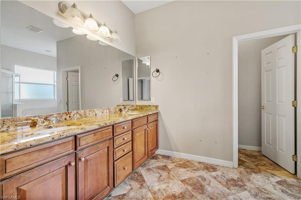 12446 Rock Ridge Lane Fort Myers, FL 33913 - Photo 8 of 38 a bathroom with a double vanity sink and a mirror