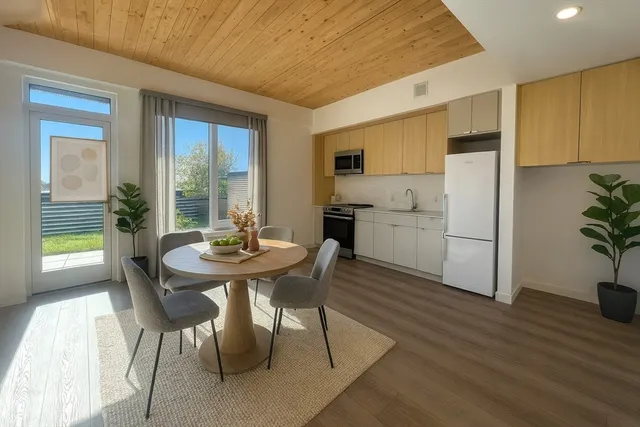 a kitchen with a table chairs refrigerator and cabinets