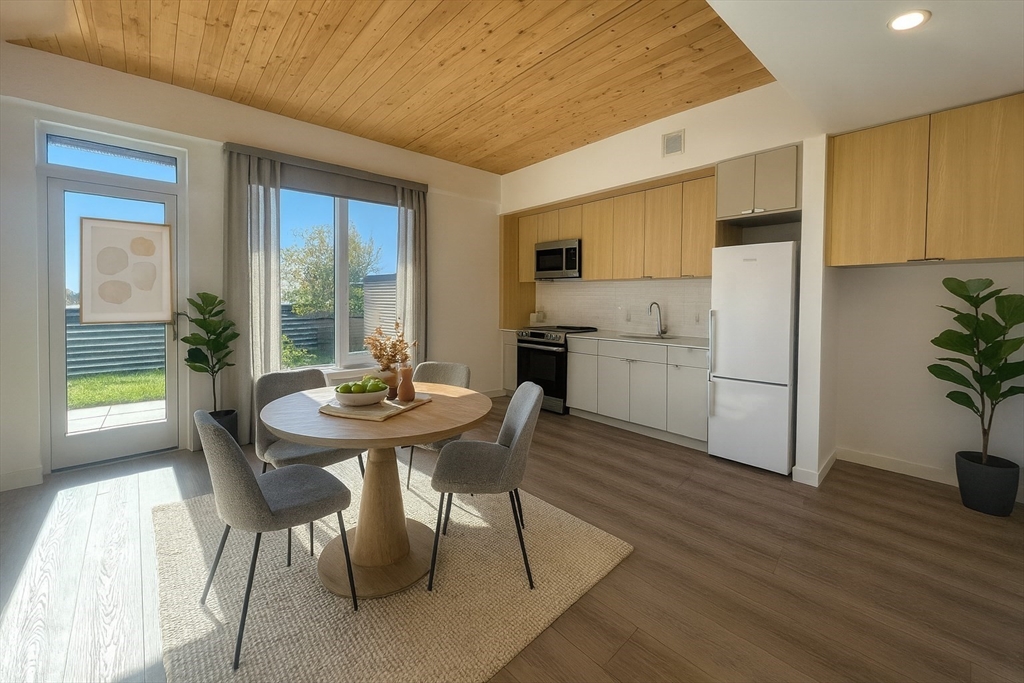 a kitchen with a table chairs refrigerator and cabinets