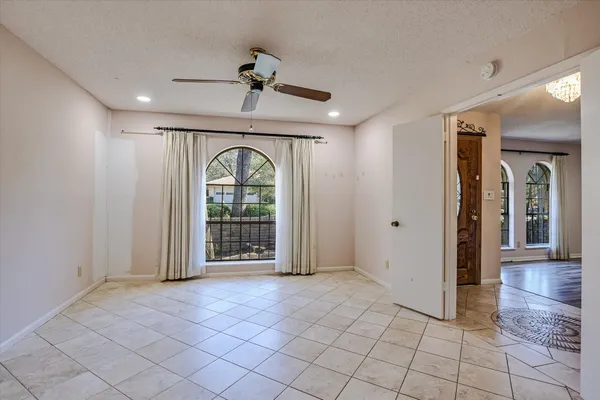 a view of a livingroom with a ceiling fan & entryway