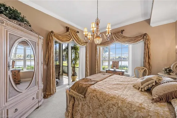 a bedroom with a bed a mirror and windows