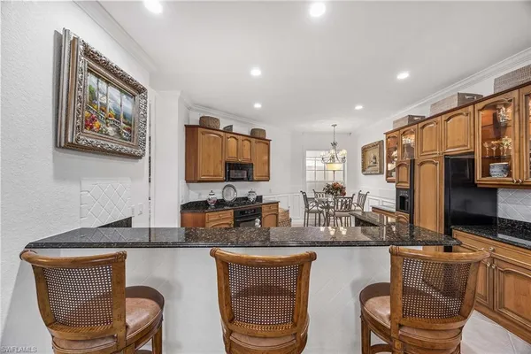 a kitchen with stainless steel appliances granite countertop a sink and a refrigerator
