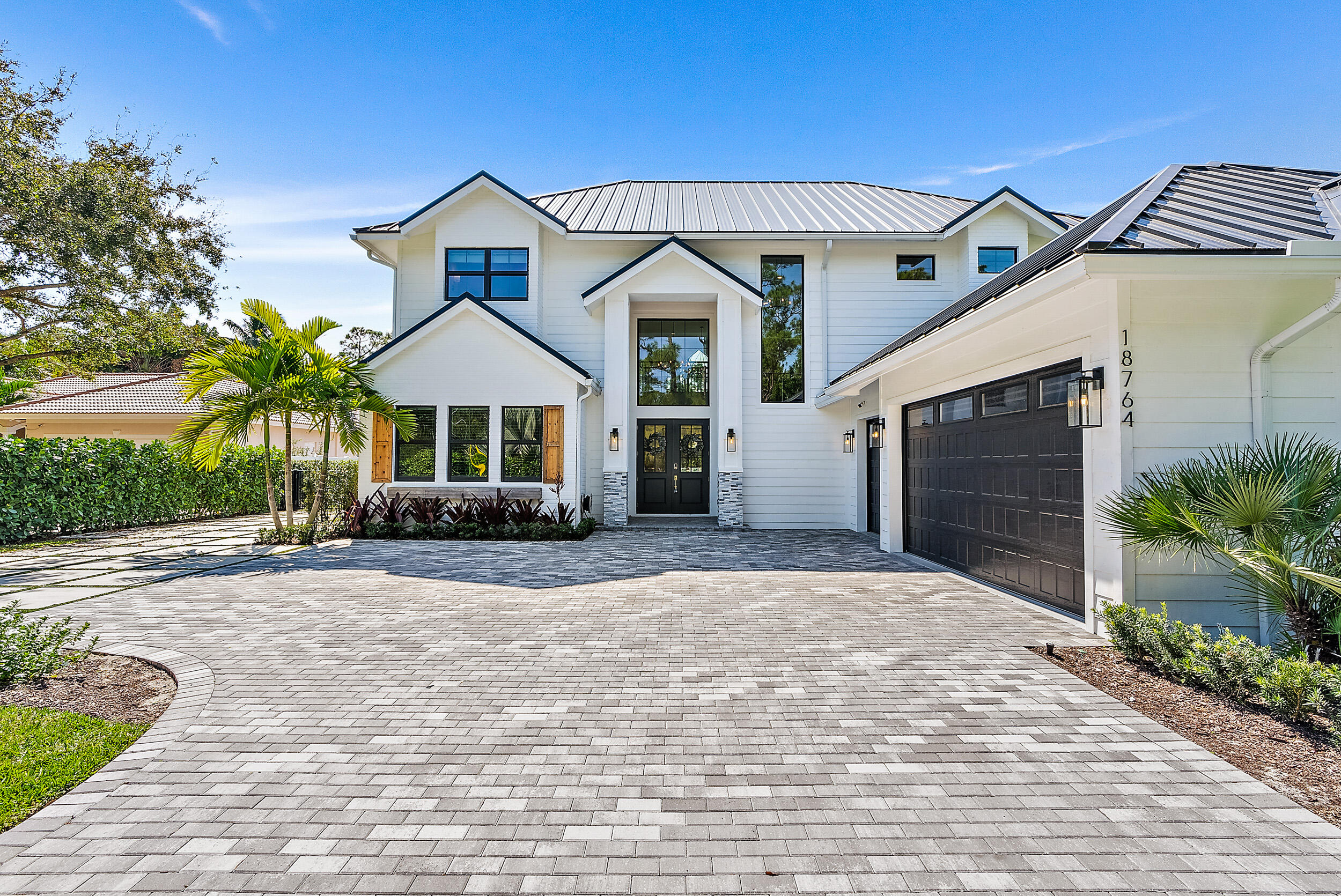 18764 Southeast Jupiter River Drive Jupiter, FL 33458 - Photo 14 of 67 a front view of a house with a yard and garage