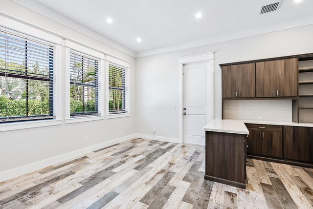 a large white kitchen with kitchen island a sink stainless steel appliances and cabinets