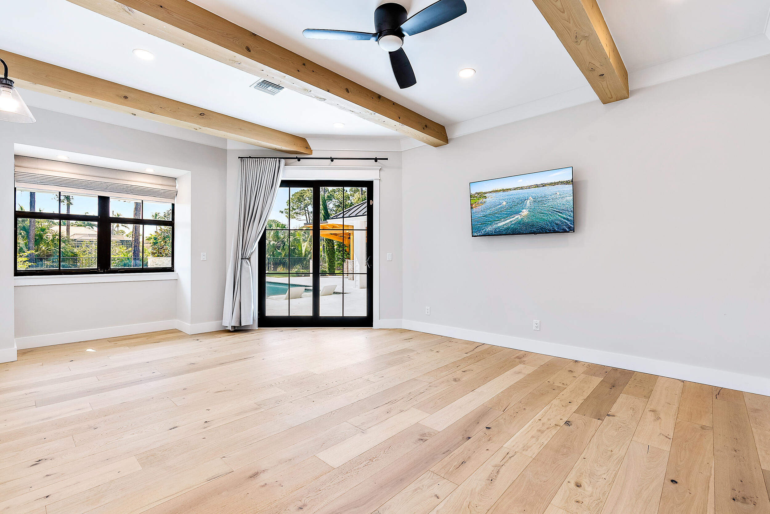 18764 Southeast Jupiter River Drive Jupiter, FL 33458 - Photo 40 of 67 a view of an empty room with a window and wooden floor