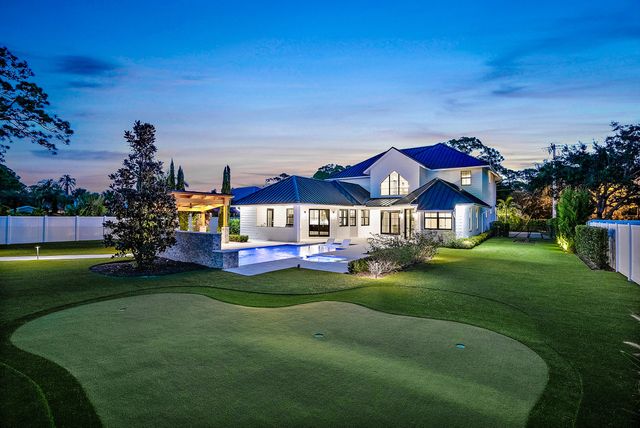a view of a house with swimming pool and sitting area