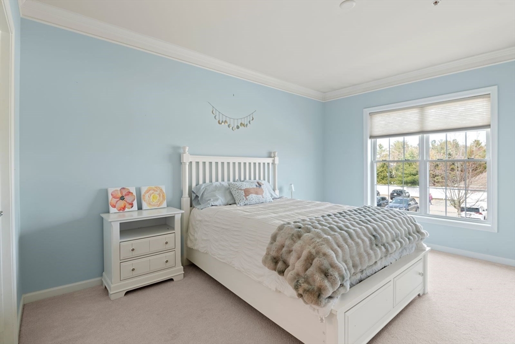 204 Clocktower Drive, Unit 202 Waltham, MA 02452 - Photo 14 of 25 a bed sitting in a bedroom next to a window