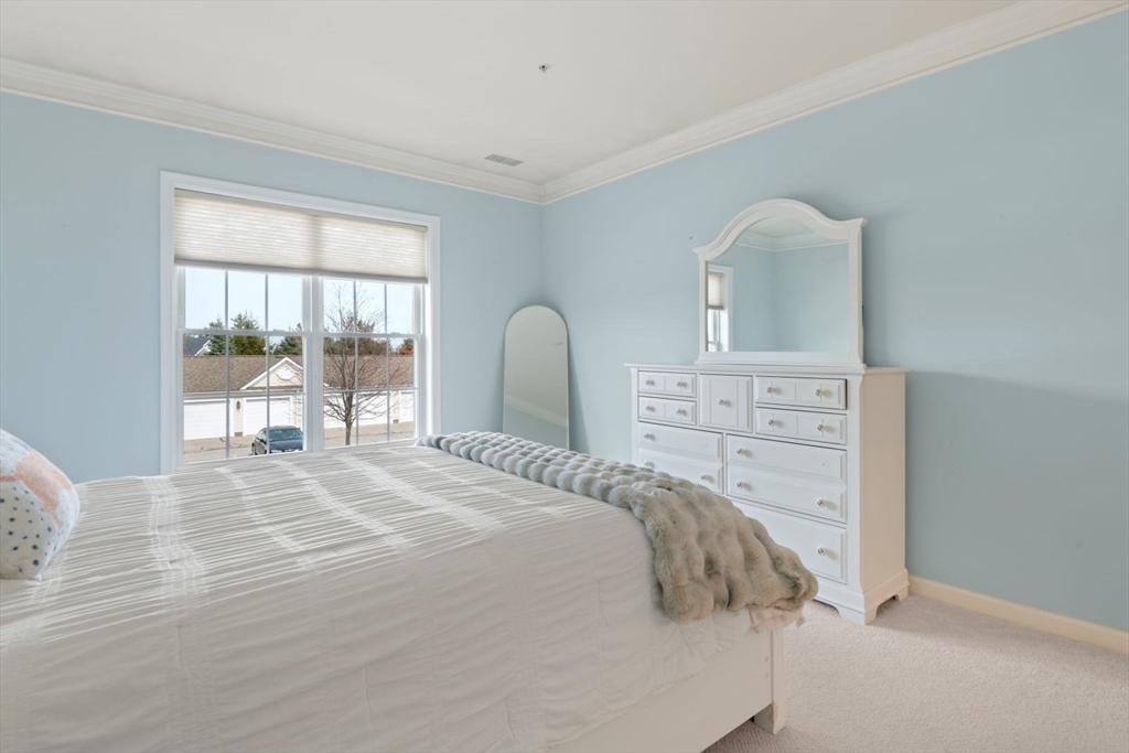 204 Clocktower Drive, Unit 202 Waltham, MA 02452 - Photo 16 of 25 a bedroom with a bed and a large window