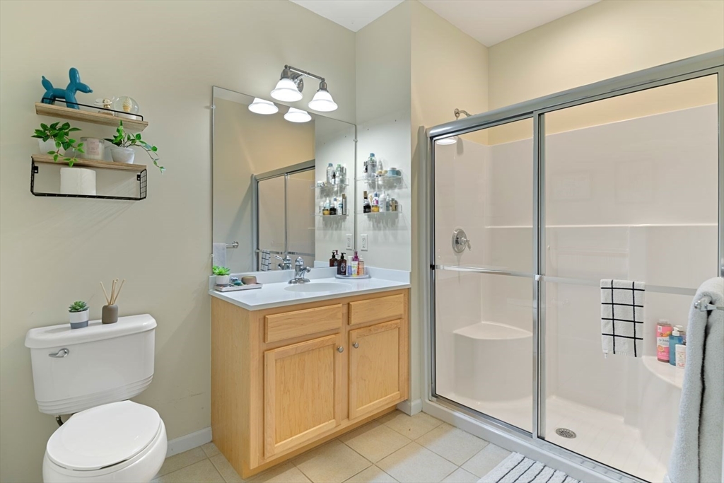 204 Clocktower Drive, Unit 202 Waltham, MA 02452 - Photo 18 of 25 a bathroom with a toilet a sink and glass door