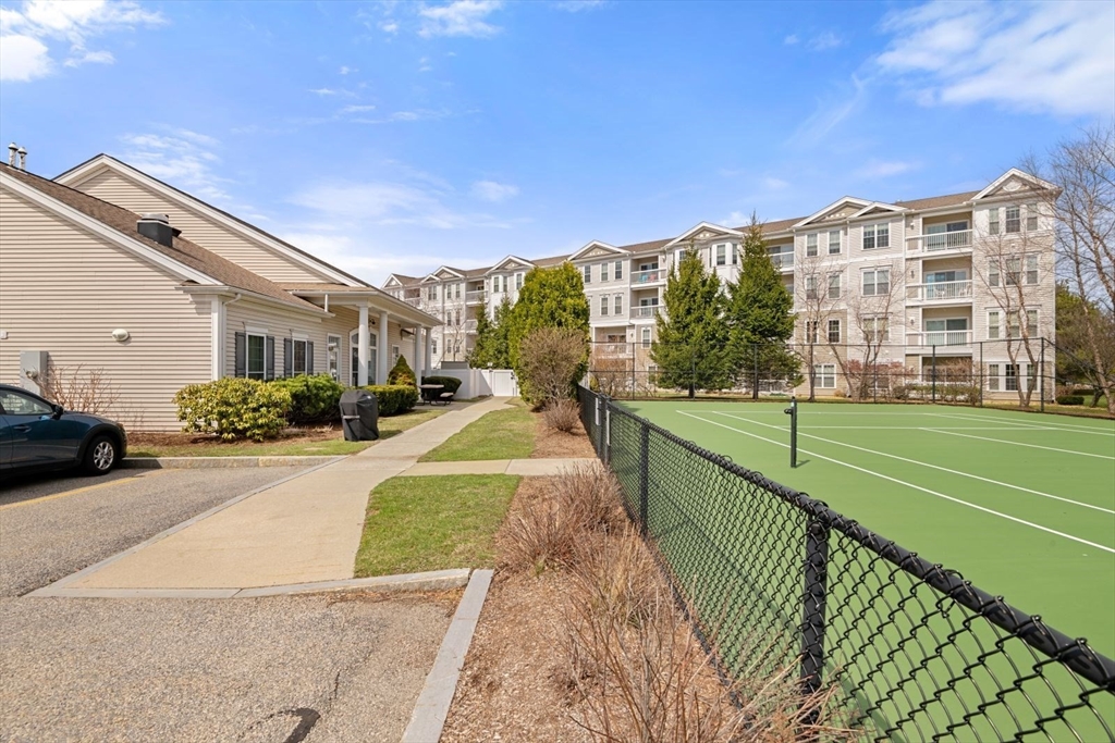 204 Clocktower Drive, Unit 202 Waltham, MA 02452 - Photo 24 of 25 a view of a building next to a yard