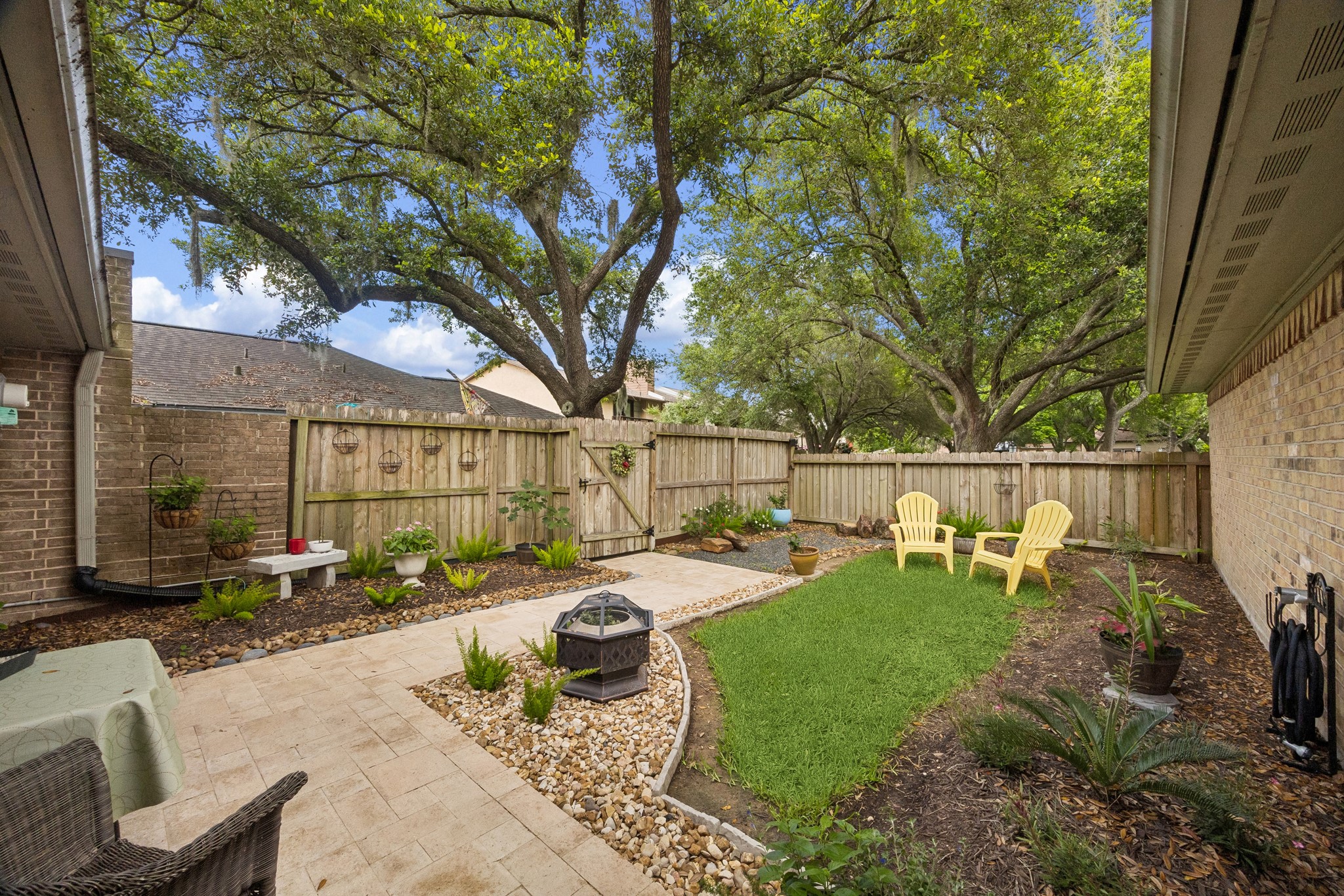 2102 Casa Rio Circle Dickinson, TX 77539 - Photo 16 of 22 Private, fully fenced backyard oasis showcasing extensive professional landscaping/hardscaping investments by Seller. Beautiful stone walkways, curated garden beds, mature trees! Multiple outdoor seating areas creates a peaceful setting for entertaining or unwinding. Seller added French Drain provides enhanced drainage, while the beautifully maintained grounds reflect the same attention to detail found throughout the home. ***Bonus ~ Seller added gutter guards ~ Soffits replaced & repainted***