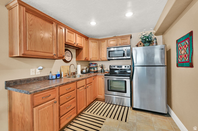 1926 East Gray Fox Drive Draper, UT 84020 - Photo 22 of 31 Kitchenette with a considerable amount of cabinet and counter space, stainless steel appliances, and a tile flooring.