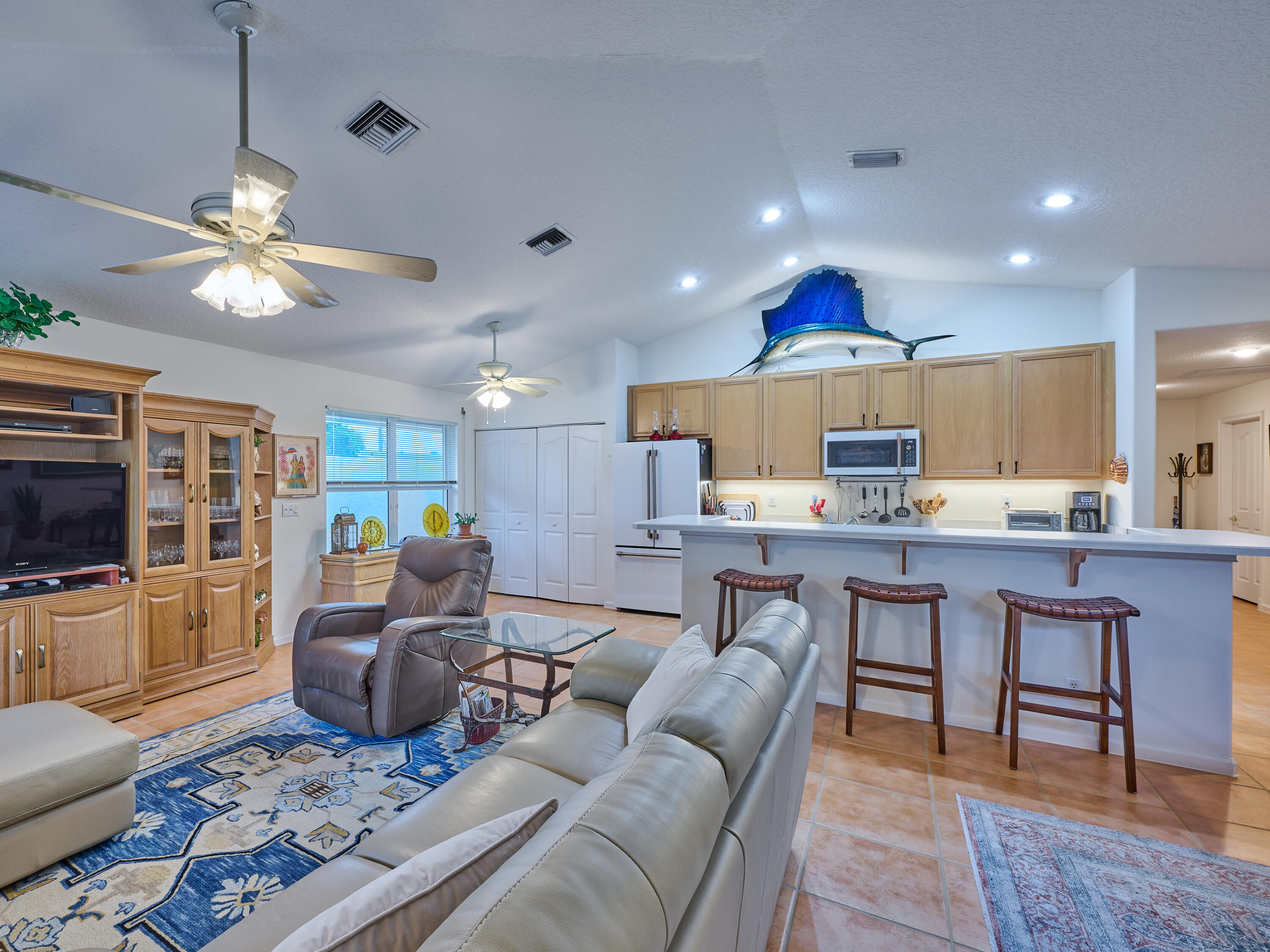 471 Neptune Road Juno Beach, FL 33408 - Photo 3 of 13 a living room with furniture a flat screen tv and kitchen view