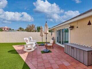 471 Neptune Road Juno Beach, FL 33408 - Photo 7 of 13 a view of an chairs and table in the patio