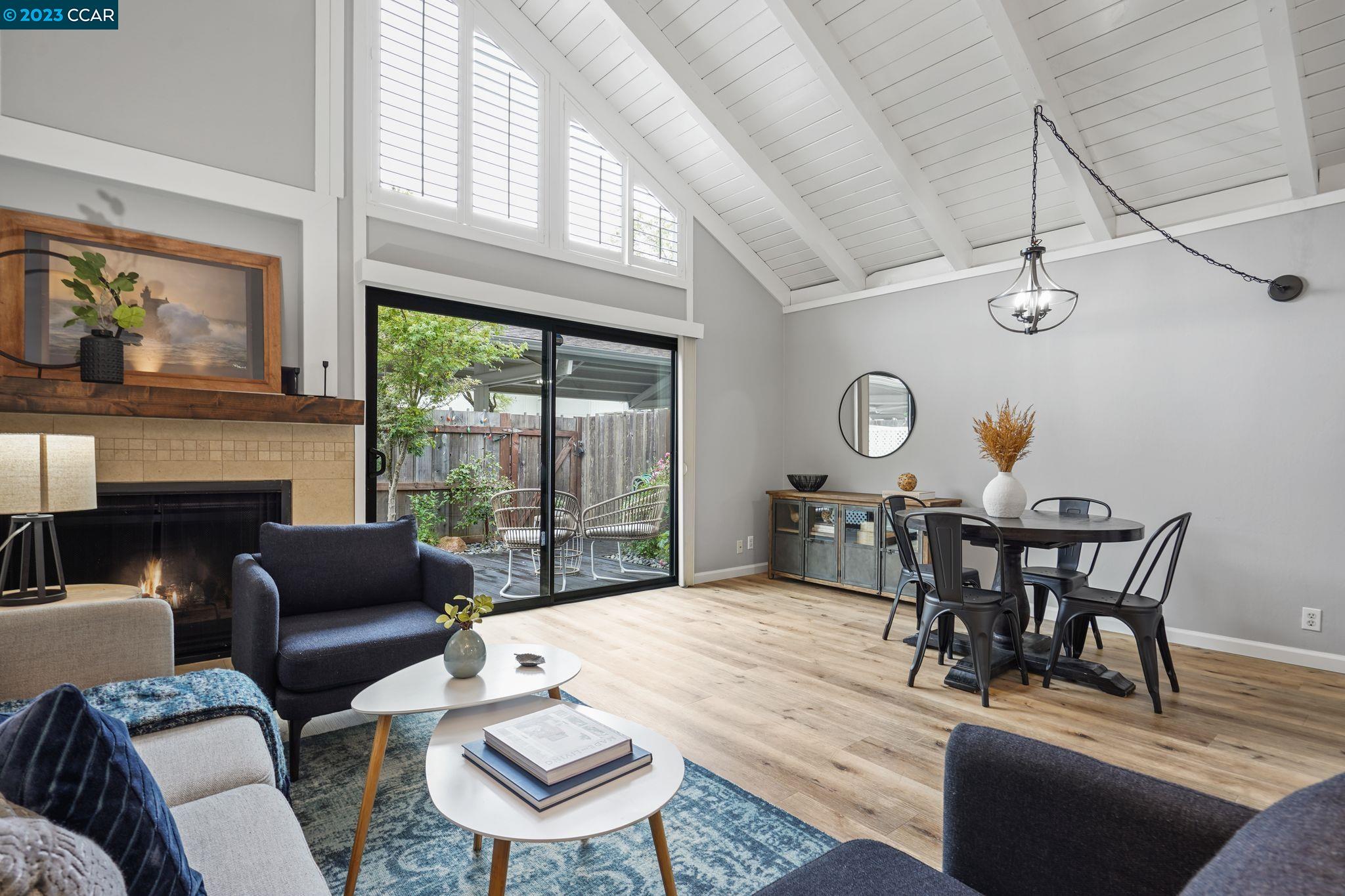 a living room with furniture a fireplace and a large window
