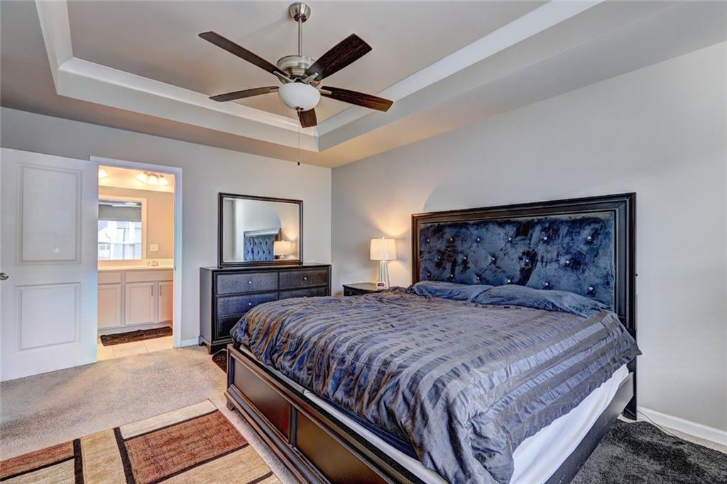 1123 Elyse Lane Mableton, GA 30126 - Photo 12 of 29 a bedroom with a large bed and a chandelier