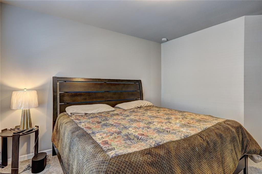 1123 Elyse Lane Mableton, GA 30126 - Photo 17 of 29 a bed sitting in a bedroom with a lamp