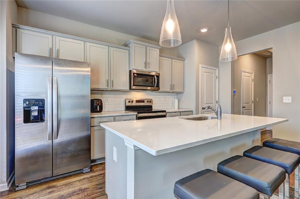 1123 Elyse Lane Mableton, GA 30126 - Photo 6 of 29 a kitchen with a refrigerator a microwave a sink and chairs