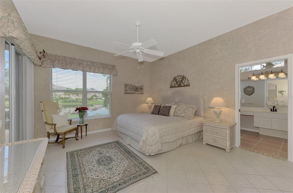3413 Pennyroyal Road Port Charlotte, FL 33953 - Photo 28 of 88 a spacious bedroom with a bed and a chandelier