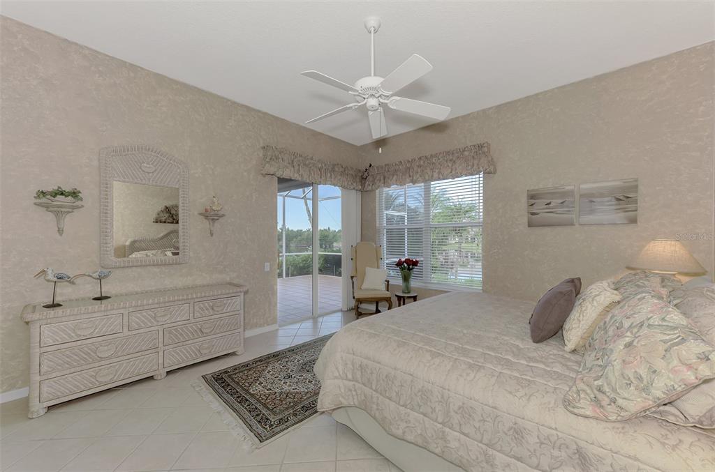 3413 Pennyroyal Road Port Charlotte, FL 33953 - Photo 29 of 88 a bedroom with a large bed and a chandelier fan