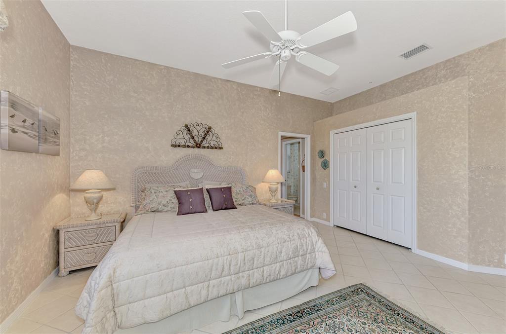 3413 Pennyroyal Road Port Charlotte, FL 33953 - Photo 30 of 88 a bedroom with a bed and a chandelier