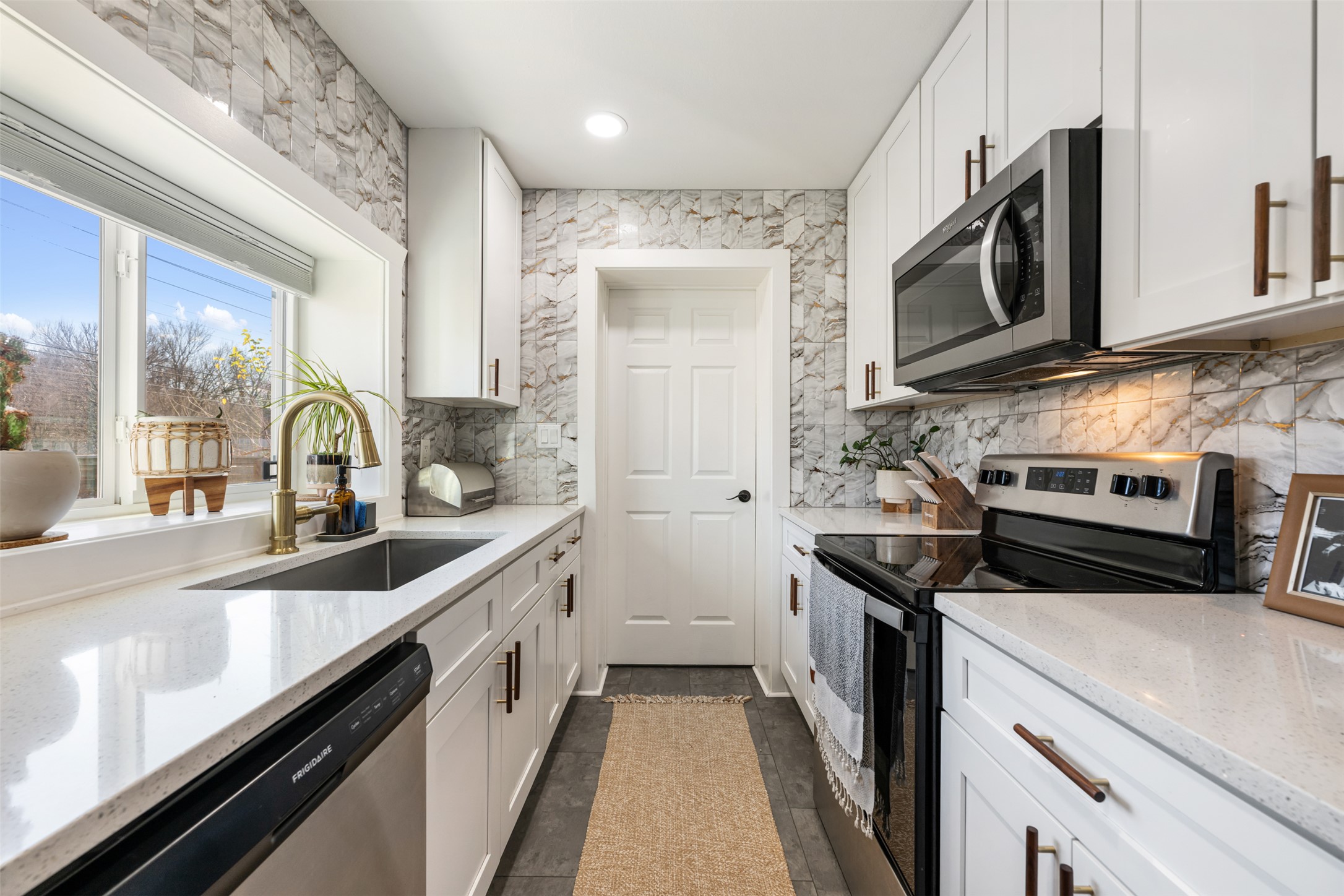 1616 Webberville Road, Unit A Austin, TX 78721 - Photo 14 of 35 Kitchen with stainless steel appliances, white cabinets, light stone counters, and recessed lighting