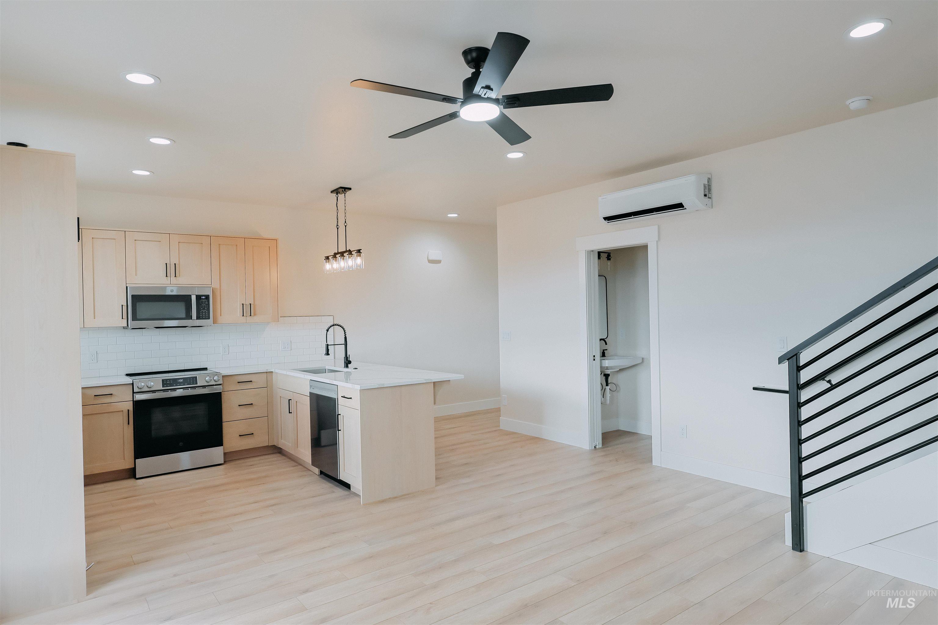 10 North Crk Way Cascade, ID 83611 - Photo 5 of 24 Kitchen with light wood finish cabinets, stainless steel appliances, a peninsula, decorative light fixtures, and light wood-style floors